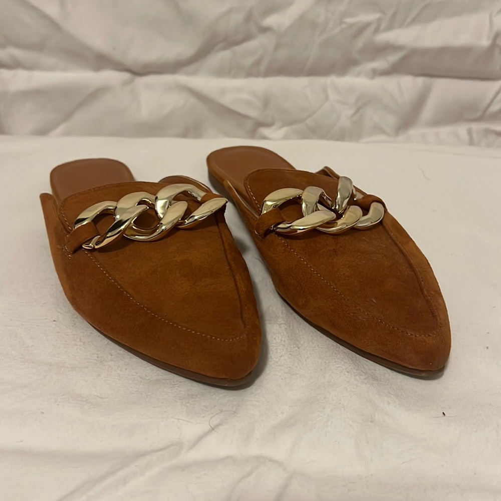 Brown suede mules with gold chain detail.